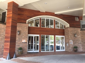 Tropical hardwood cladding around an arched hotel entrance