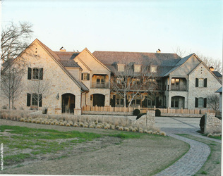 Stone estate home with a natural wood shake roof